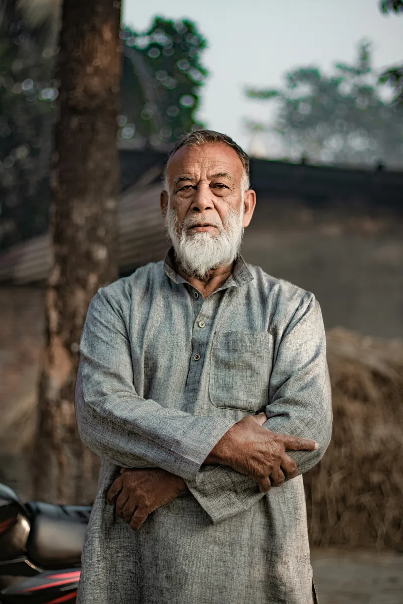 Portrait of a man with a white beard and folded arms